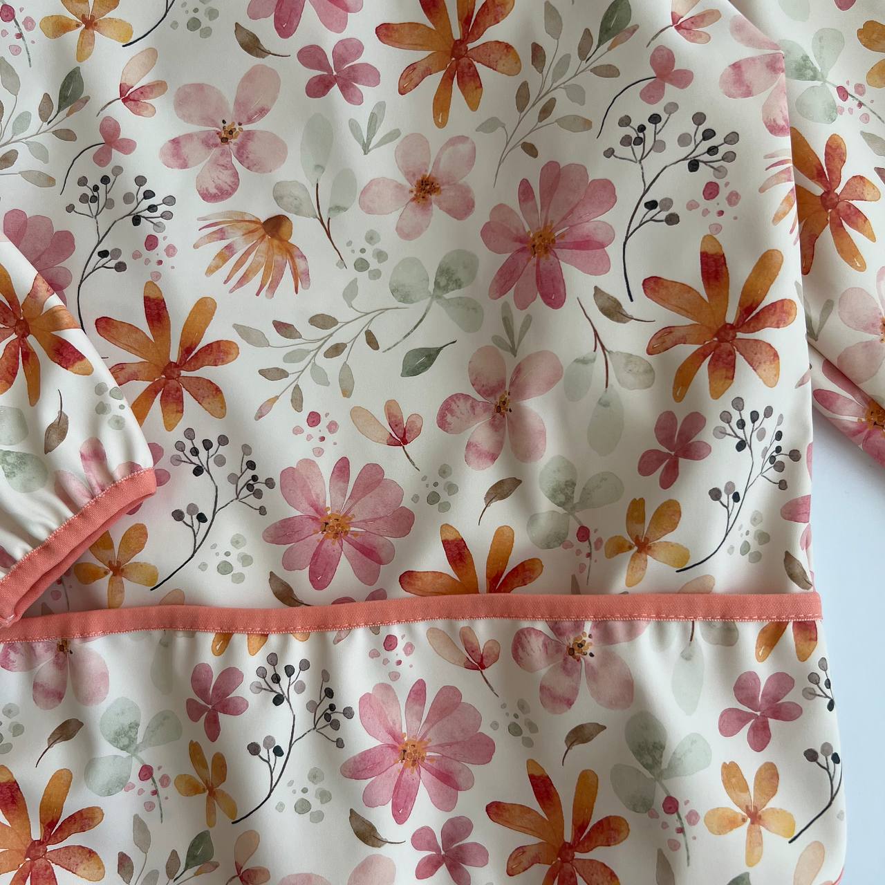 Floral-patterned baby outfit with pink trim on a white background