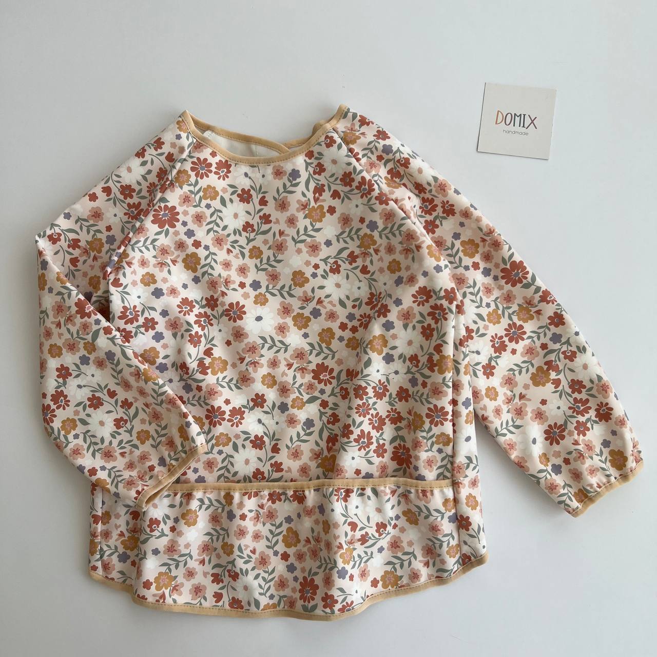 Floral-patterned sweatshirt on a white background with a brand tag visible.